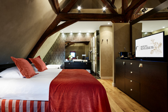 Lit king-size confortable dans l’une des suites de l’Hôtel Van der Valk Sélys Liège.