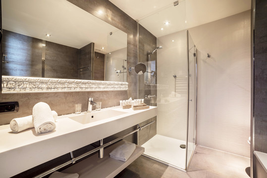 Salle de bain élégante de la Suite Deluxe avec baignoire et équipements haut de gamme.